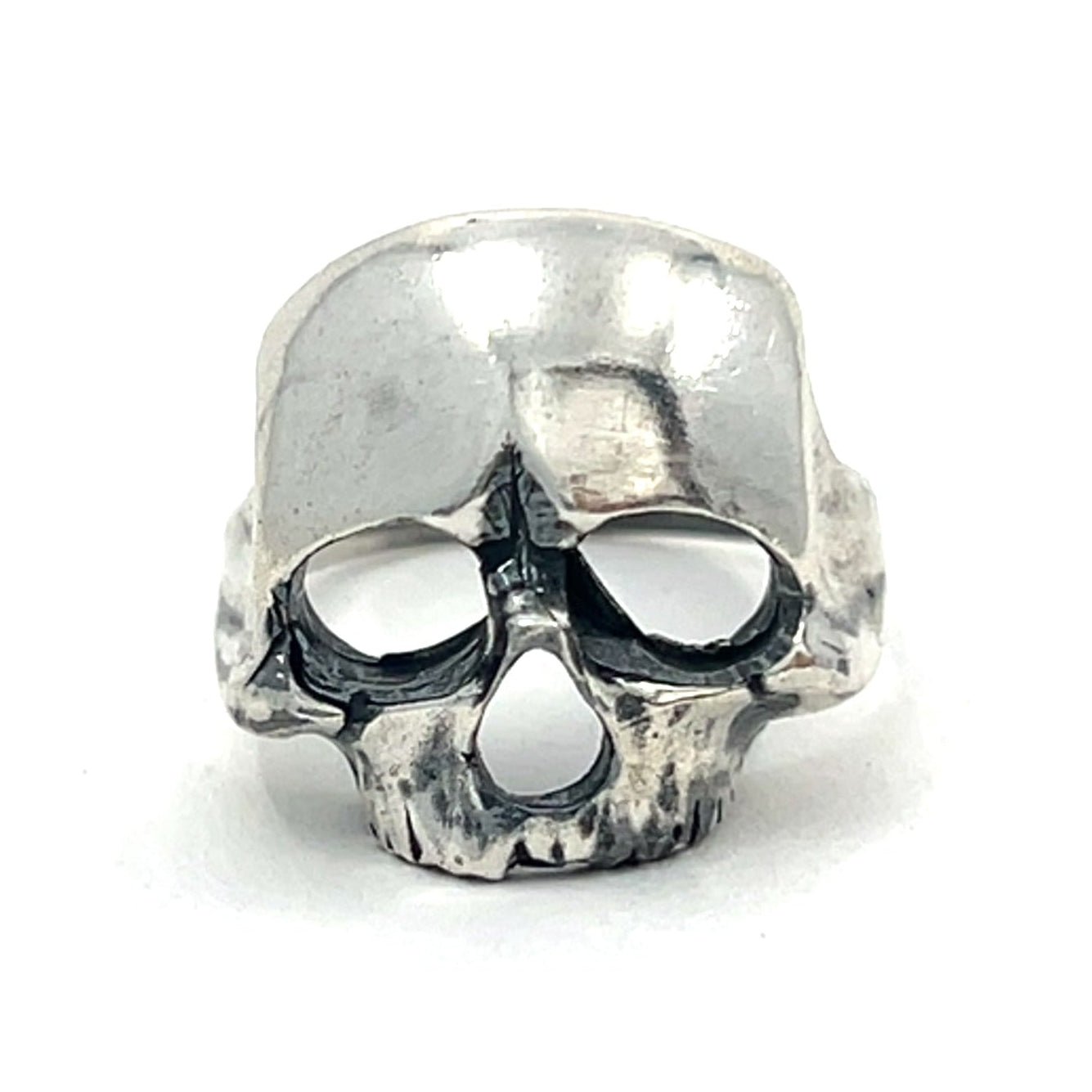 Silver skull-shaped ring on a white background