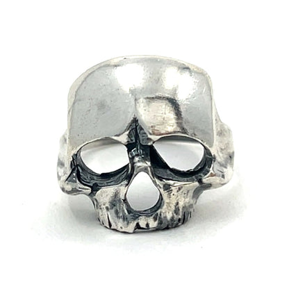 Silver skull-shaped ring on a white background